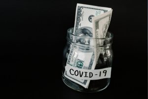 jar that says covid-19 with cash in it